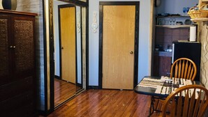 A dining area with a wooden table and chairs, a cabinet, and a mirror. - Small studio in the quite neighbourhood. (Flagstaff)