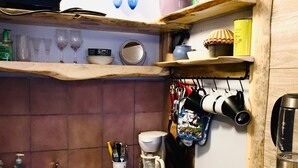 A compact kitchen with a microwave, coffee maker, and various kitchen utensils. - Small studio in the quite neighbourhood. (Flagstaff)