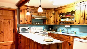 A kitchen with wooden cabinets, a microwave, a stove, and a sink.