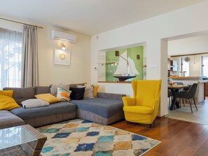 Un salon avec un canapé, un fauteuil et un tapis coloré.