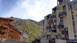 A building with multiple balconies and a sign for 'Snack Pizza'.