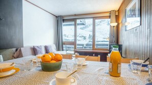 A dining area with a table set for breakfast, including oranges, a glass of juice, and a bowl of fruit. - Beautiful apartment for 6 guests with WIFI and balcony (Les Boisses)