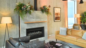 A modern living room with a fireplace, leather sofas, and a large window. - Sudima Auckland City (Auckland)
