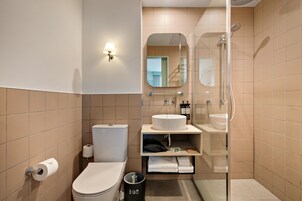 A modern bathroom with a toilet, sink, and shower.
