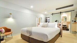 A modern bedroom with a large bed, a bedside table, a chair, and a mirror. - Sudima Auckland City (Auckland)