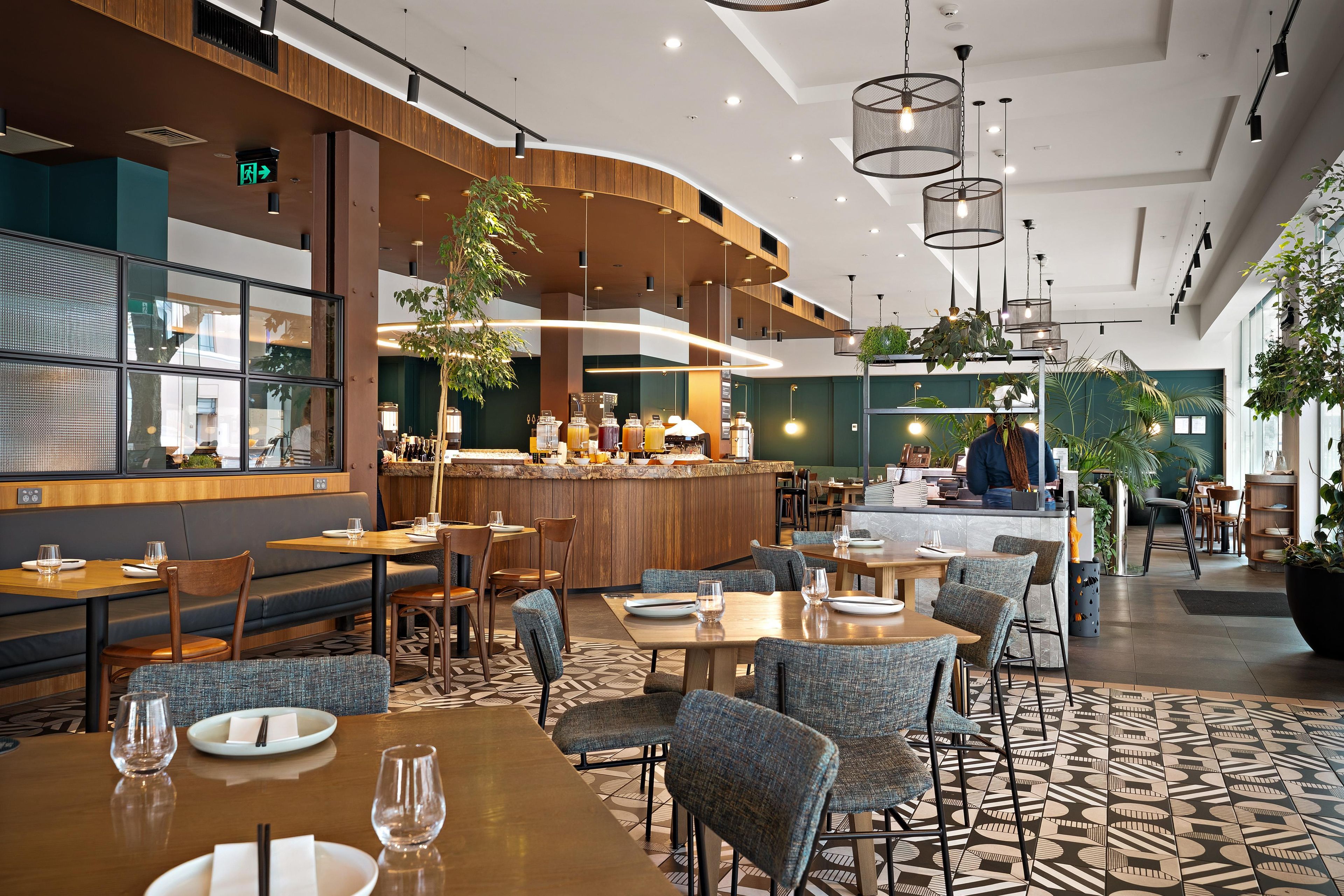Un interior de restaurante moderno con una zona de bar, arreglos de asientos y una barra.