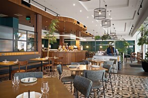 A modern restaurant interior with a bar area, seating arrangements, and a counter. - Sudima Auckland City (Auckland)