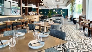 A modern restaurant with a mix of seating options, including tables and booths, and a bar area in the background. - Sudima Auckland City (Auckland)