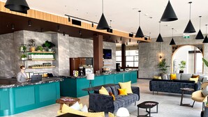 A modern lobby with a reception desk, seating area, and a bar. - Sudima Auckland City (Auckland)