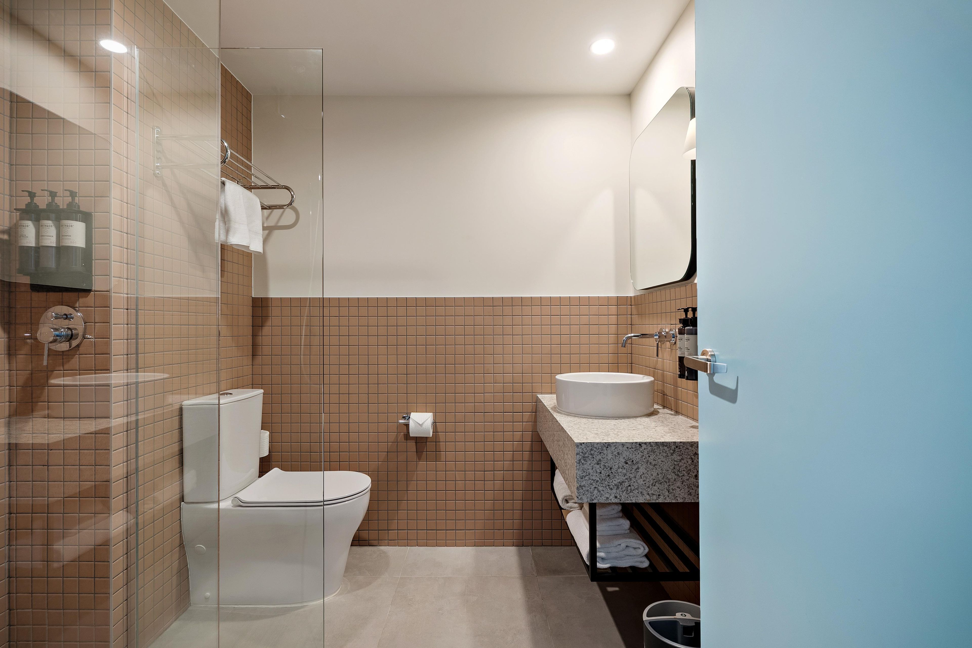 A modern bathroom with a toilet, sink, and shower area.