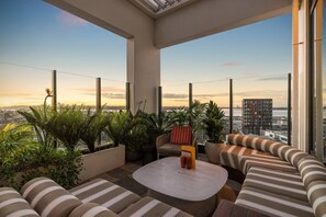 A rooftop terrace with a seating area, potted plants, and a view of the cityscape. - Sudima Auckland City (Auckland)