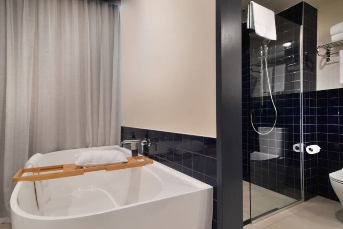 A modern bathroom with a freestanding bathtub, a glass-enclosed shower, and a toilet.