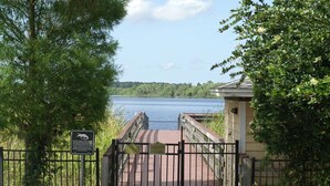 A wooden boardwalk leading to a lake with a metal gate and a sign. - Ev7836ha - Bahama Bay Resort - 3 Bed 2 Baths Condo (Davenport)