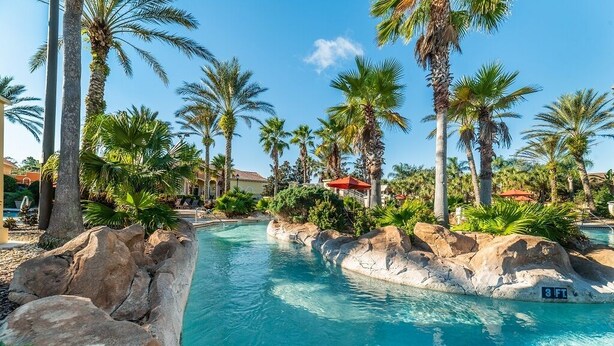 A pool area with clear blue water, surrounded by palm trees and rocks. - Ev7861ha - Regal Palms Resort & Spa - 4 Bed 3 Baths Townhouse (Davenport)