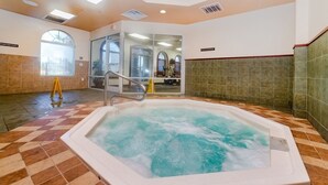 A large indoor hot tub with a checkered floor pattern, a glass door entrance, and a visible exit sign. - Ev7861ha - Regal Palms Resort & Spa - 4 Bed 3 Baths Townhouse (Davenport)