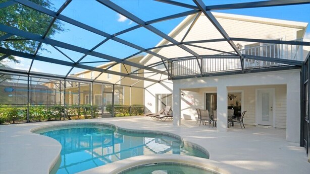 A swimming pool with a glass ceiling, surrounded by lounge chairs and a patio area. - Ev8090ha - Providence - 4 Bed 3 Baths Villa (Davenport)