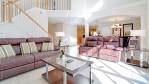 A spacious living room with a high ceiling, a staircase, and a dining area with a glass table. - Ev8090ha - Providence - 4 Bed 3 Baths Villa (Davenport)