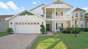 A two-story house with a front garage, a balcony on the upper floor, and a well-maintained lawn. - Ev8090ha - Providence - 4 Bed 3 Baths Villa (Davenport)