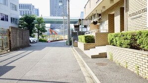 Een woonstraat met bakstenen huizen, een hijskraan en moderne gebouwen op de achtergrond.