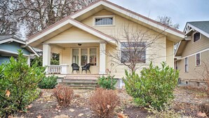 A two-story house with a front porch, two chairs, and a small garden with shrubs and fallen leaves. - Peaceful Wine Country Getaway - Walk to Downtown! (Walla Walla)