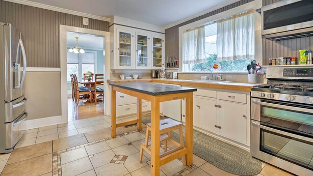 A modern kitchen with a central island, stainless steel appliances, and a dining area with a view. - Peaceful Wine Country Getaway - Walk to Downtown! (Walla Walla)