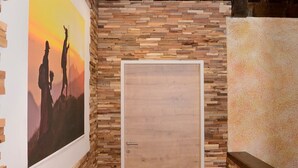 Ein Zimmer mit Holzboden, einer Tür und einer Wand mit Holzstruktur.