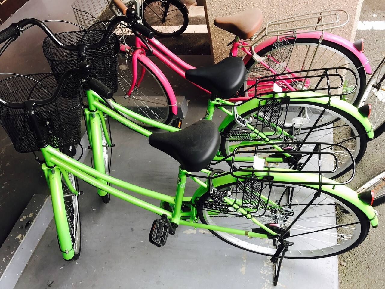 A row of bicycles parked in a covered area with a metal rack.