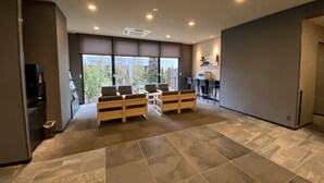 A spacious room with a large window, a seating area with wooden furniture, a kitchenette, and a tiled floor. - Hotel Route Inn Sakurai Ekimae (Sakurai)