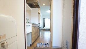 Un pasillo estrecho que lleva a una cocina con armarios de madera y un refrigerador.