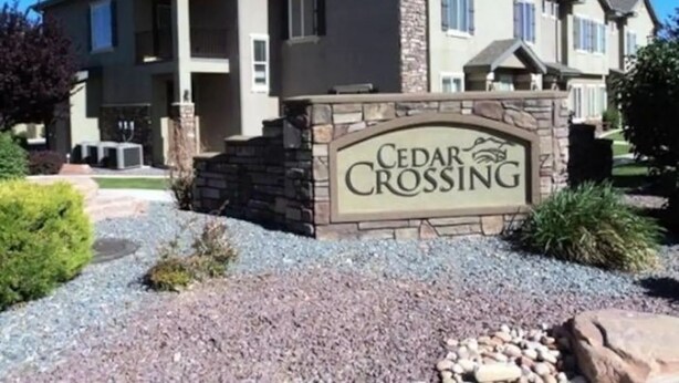 Une maison à plusieurs étages, dotée d’une façade en pierre et d’une enseigne indiquant « Cedar Crossing ».