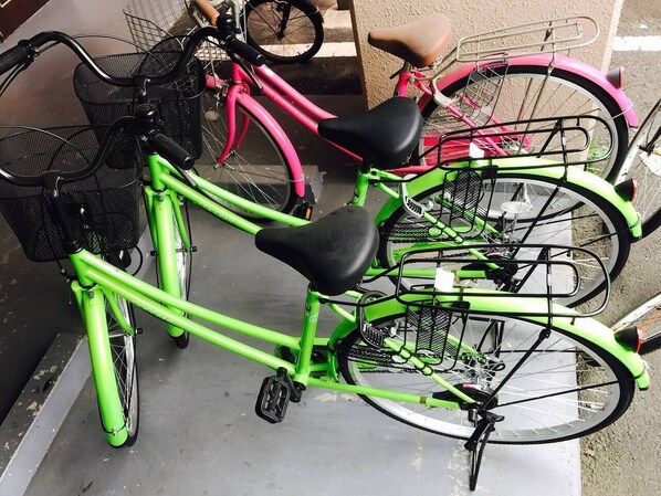 A row of bicycles parked in a covered area with a metal rack. - Hostel 758 Nagoya3P (Nagoya)