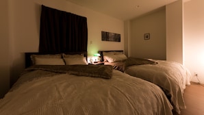 A bedroom with two beds, a nightstand with a lamp, a wall-mounted picture, and a window with curtains. - Mini Hotel Shinjuku Front 101 (Tokyo)