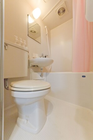 A bathroom with a toilet, sink, and shower area. - Mini Hotel Shinjuku Front 101 (Tokyo)
