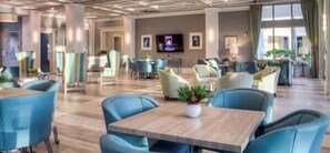 A spacious lobby with modern furniture, a flat-screen TV, and a ceiling with recessed lighting.