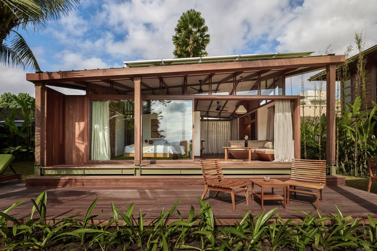 Ein modernes Haus mit einer Terrassenfläche, einem Holzterrasse und einem gläsernen Wohnbereich.