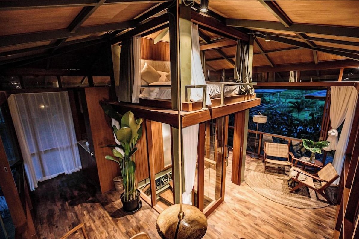 Ein Holzinterieur mit Balkon, einer Topfpflanze und Blick ins Freie.