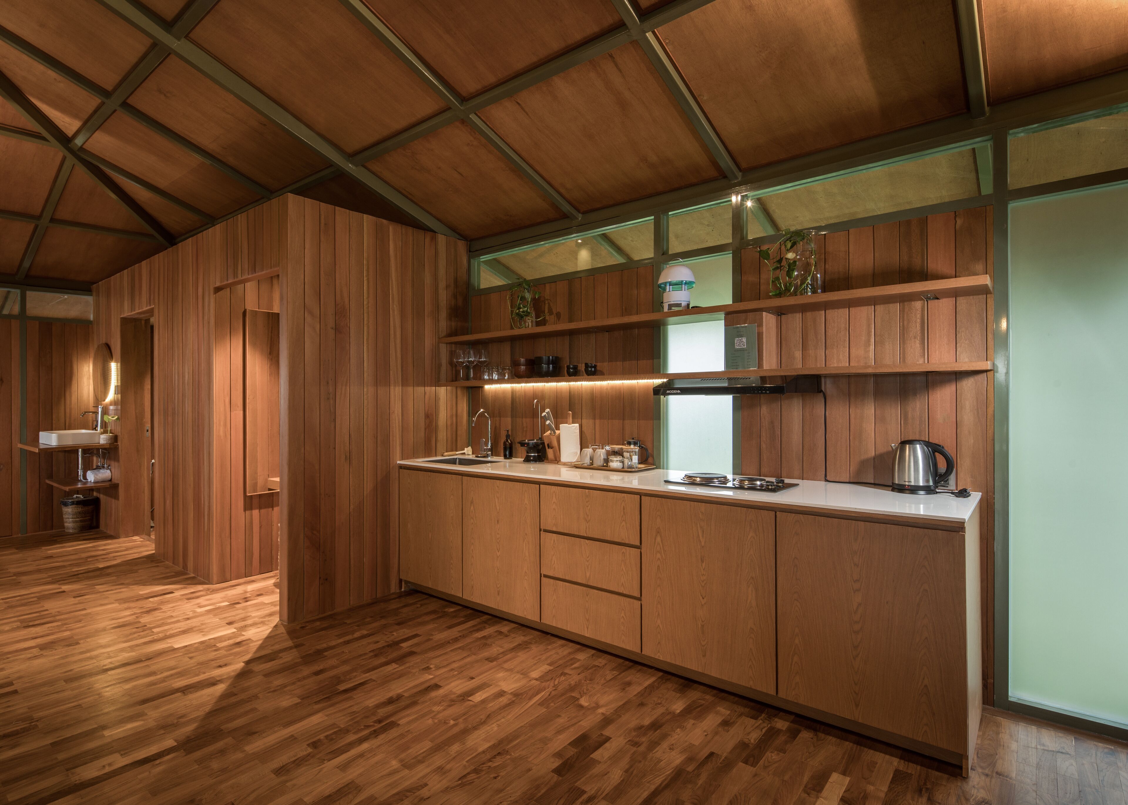 Une cuisine moderne avec des meubles en bois, un évier en acier inoxydable et une cuisinière encastrée.
