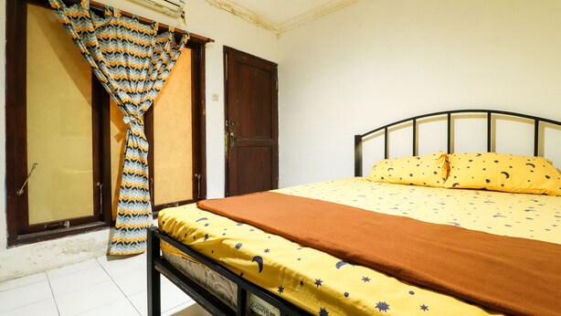 A bedroom with a bed, curtains, and a wardrobe. - Kos VIP Josh (Pogung Lor)