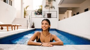 Uma piscina com vista clara da borda e degraus que levam a um nível superior.