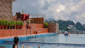 A swimming pool with a view of a cityscape in the background.