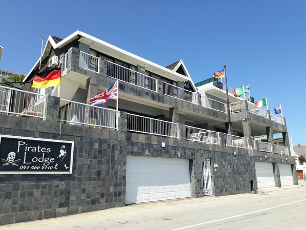 Un edificio de varios pisos con balcones, banderas y un letrero que dice 'Pirates Lodge'.