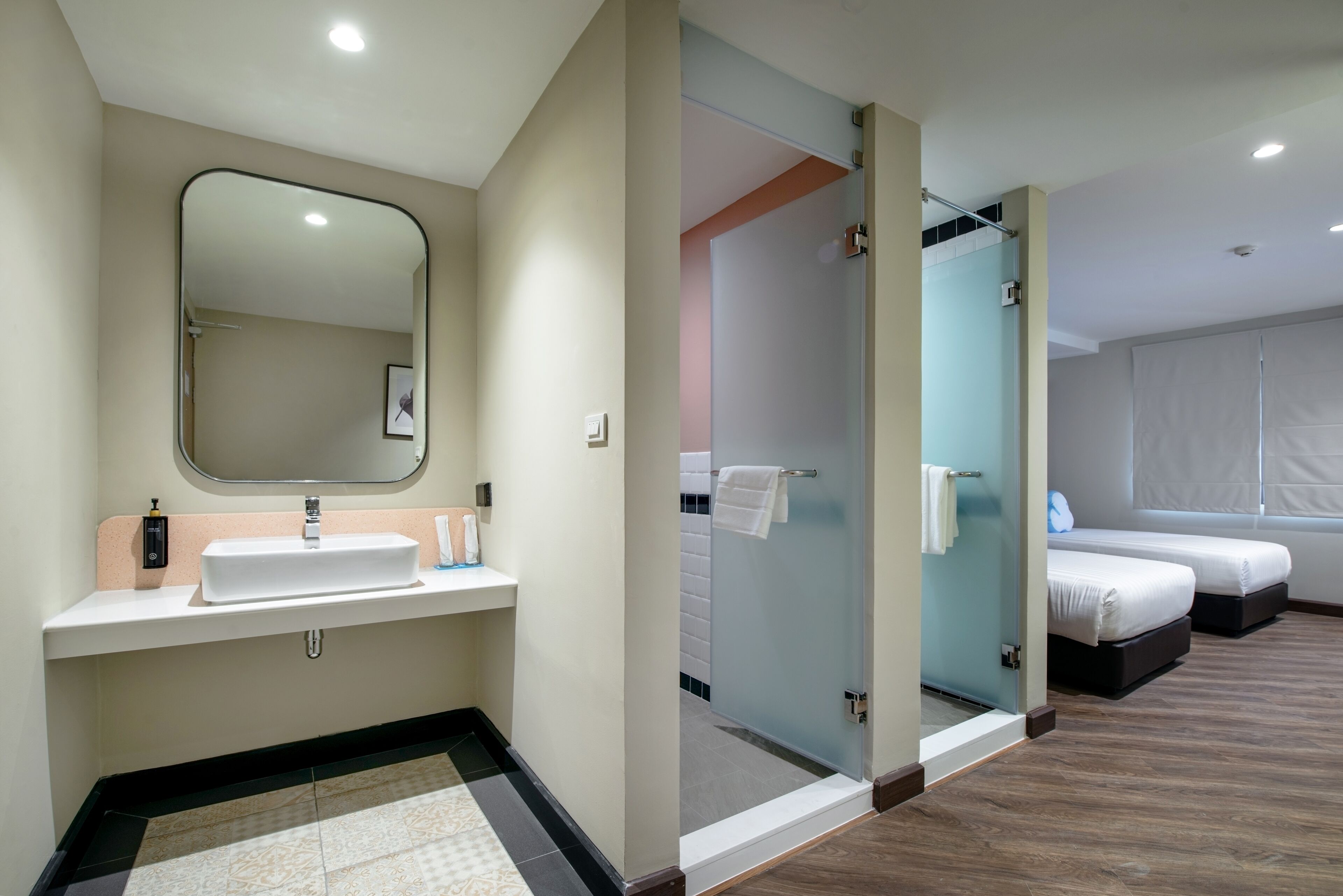 Un baño moderno con lavamanos, espejo y ducha.