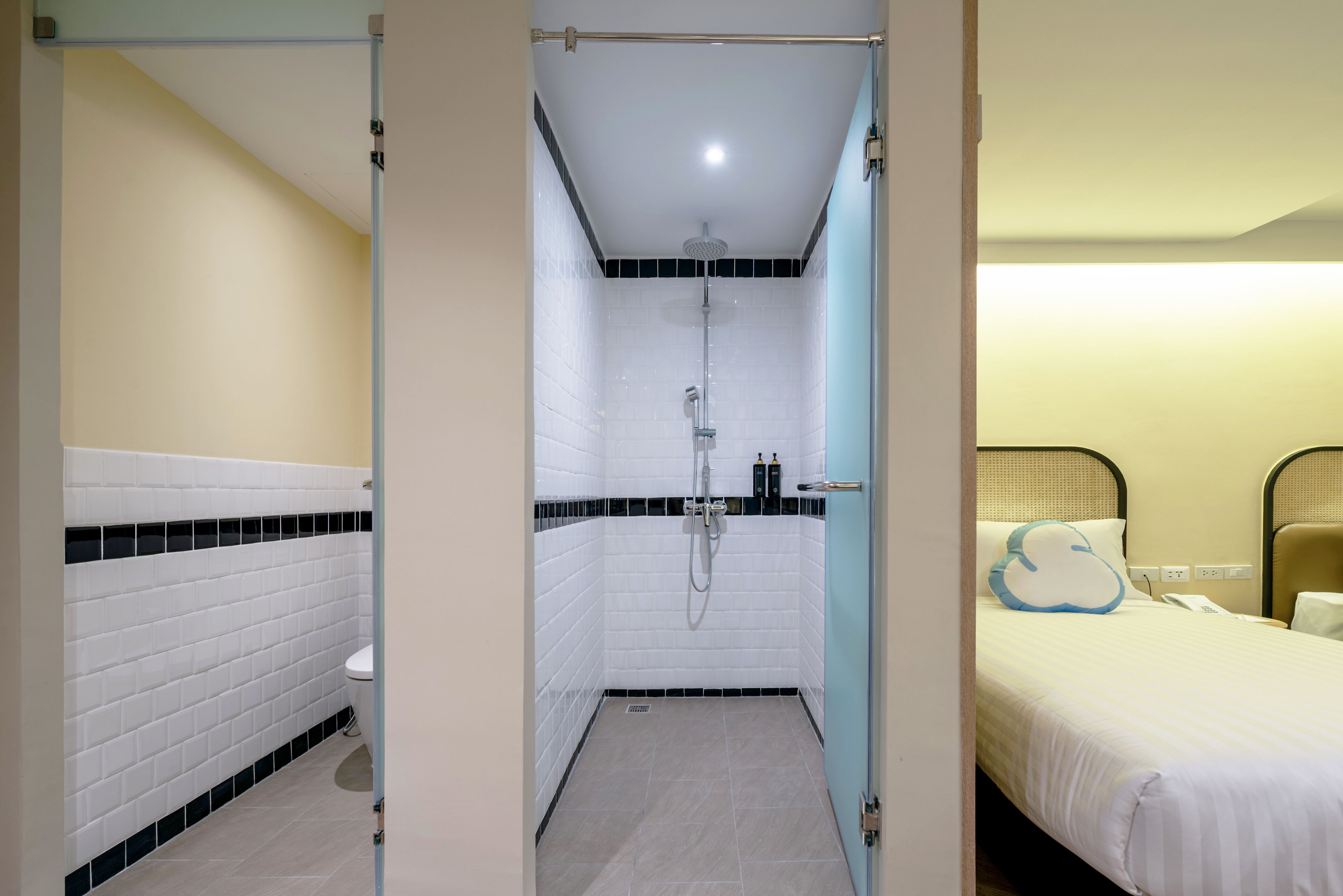 A hotel room with a shower, toilet, and bed.