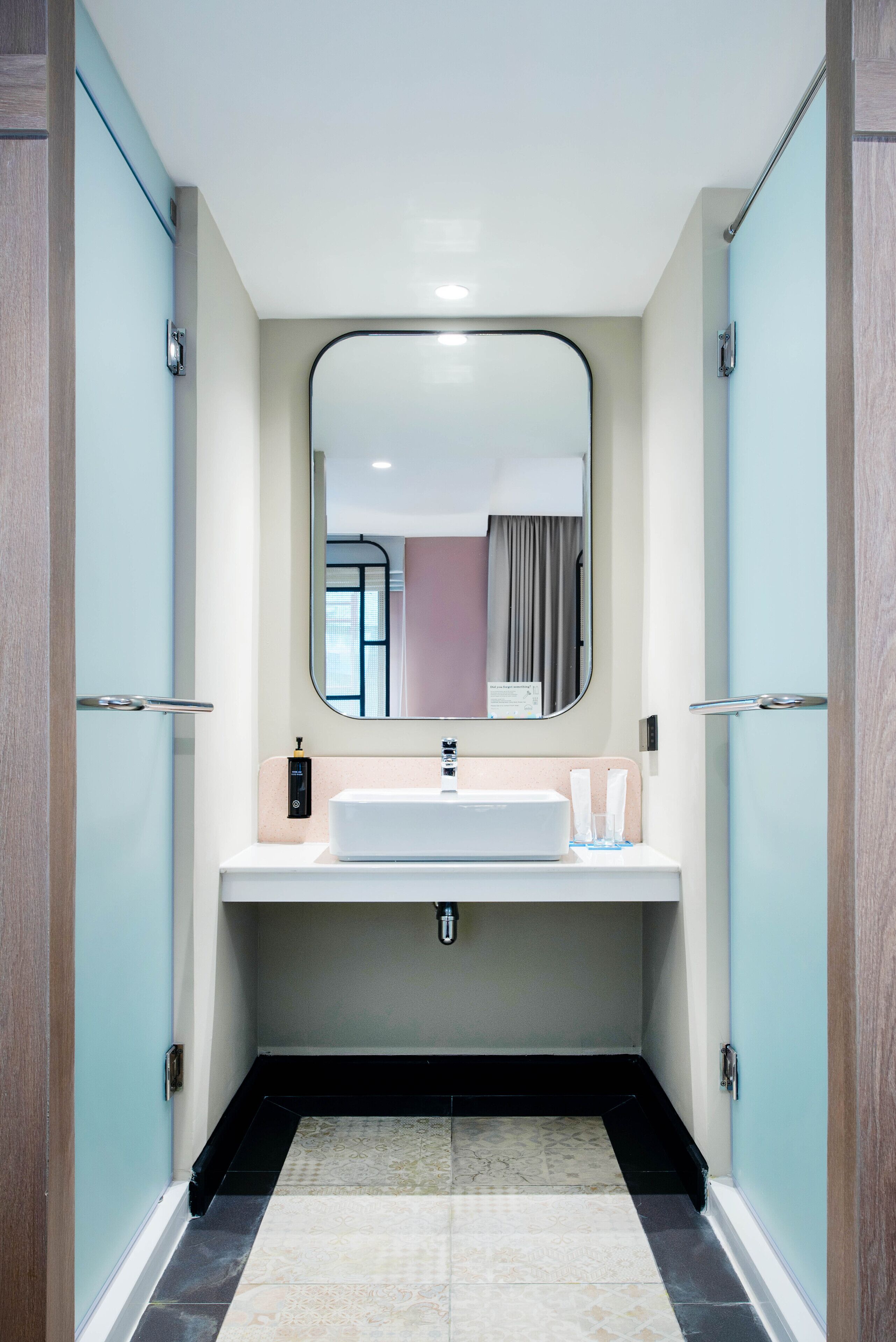 Une salle de bain moderne avec un grand miroir, un lavabo et un porte-serviettes.