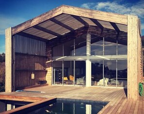 Uma casa moderna com deck de madeira e piscina.