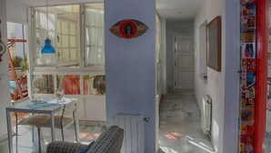 Quarto com mesa, cadeiras, radiador e parede decorada com um círculo.