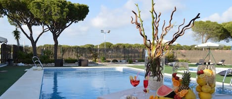 Una piscina al aire libre de temporada, sillones reclinables de piscina