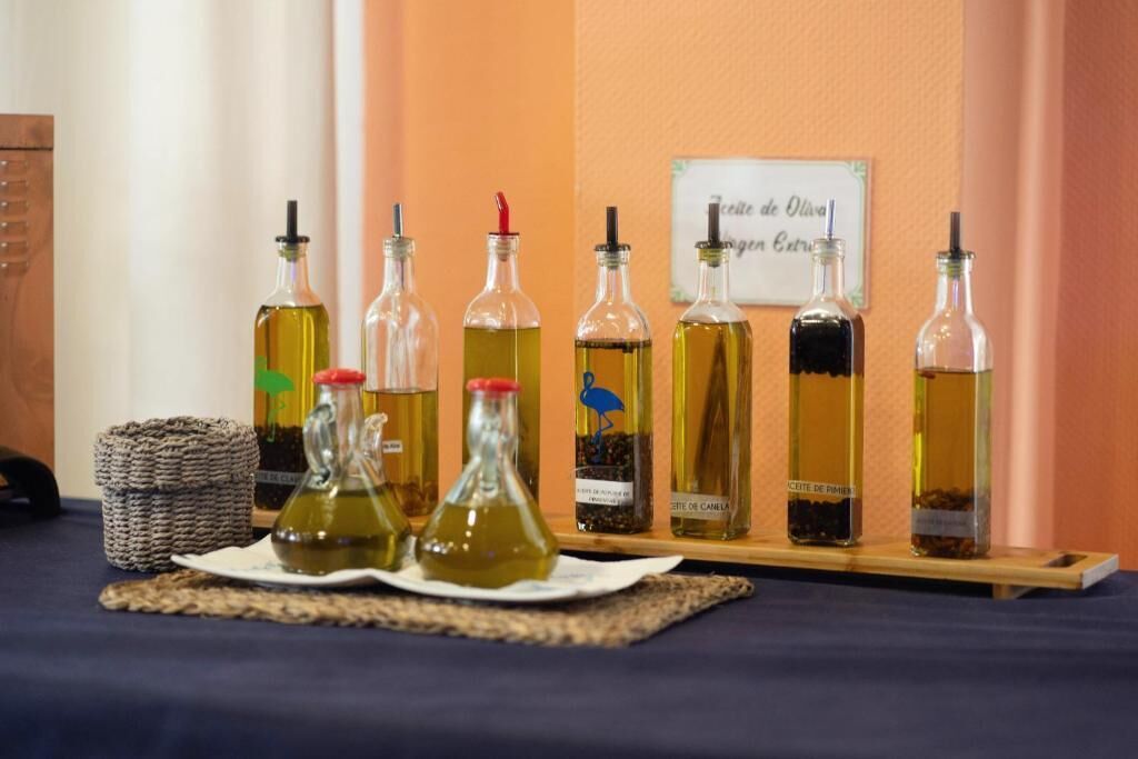 A display of olive oil bottles on a wooden shelf against a wall.