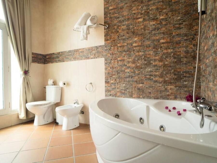 A bathroom with a large bathtub, a toilet, and a bidet.