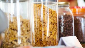 A variety of food items in transparent containers, including cereal and nuts.
